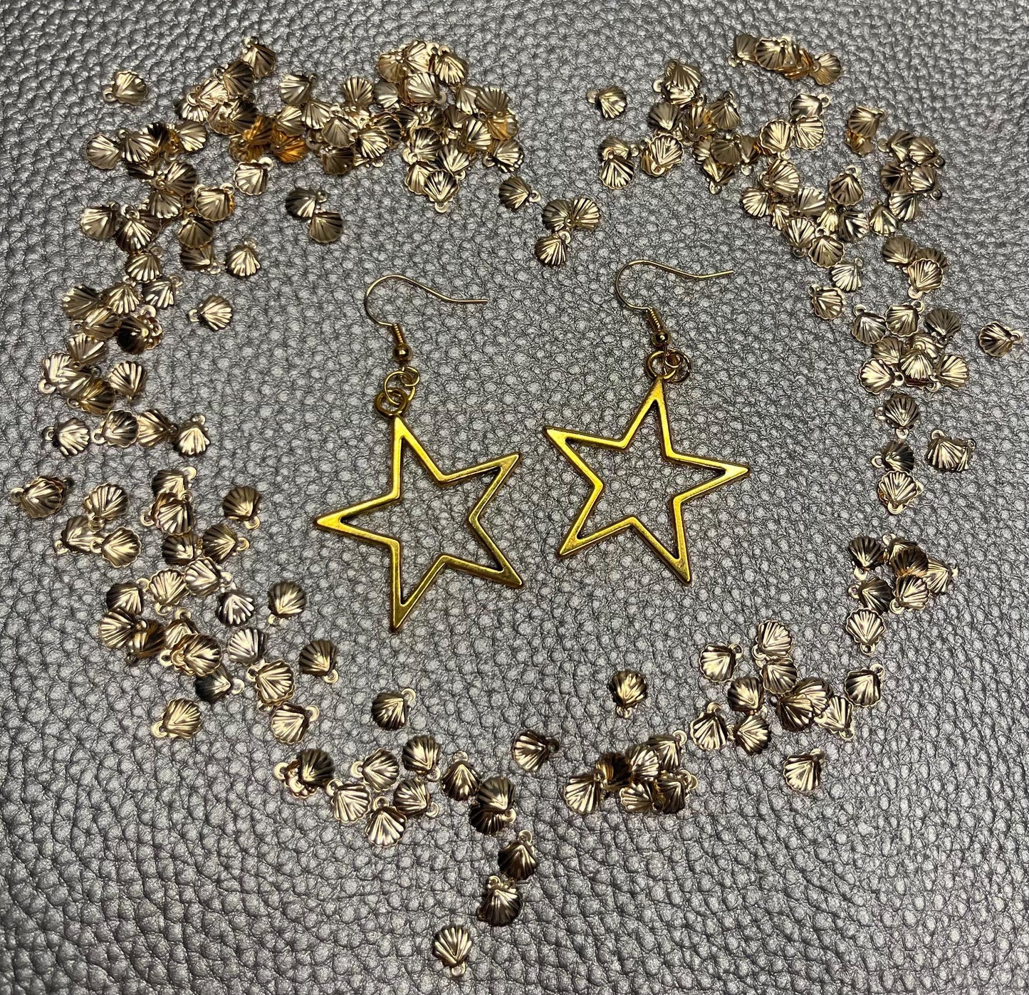Stylish large gold star dangly earrings, featuring a bold and eye-catching design perfect for elevating any outfit with a touch of glamour and shine.