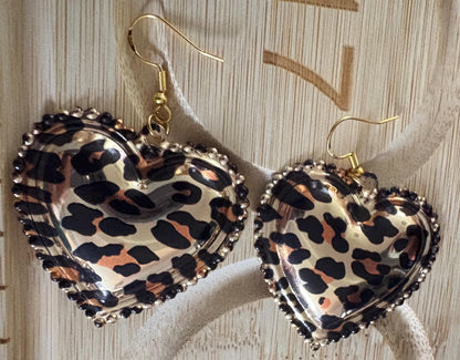 Stylish dangly earrings featuring a heart pendant design in chic leopard print, perfect for adding a touch of wild elegance to your jewelry collection and enhancing any outfit.