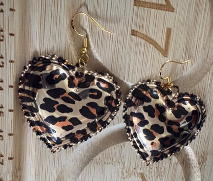 Stylish dangly earrings featuring a heart pendant design in chic leopard print, perfect for adding a touch of wild elegance to your jewelry collection and enhancing any outfit.