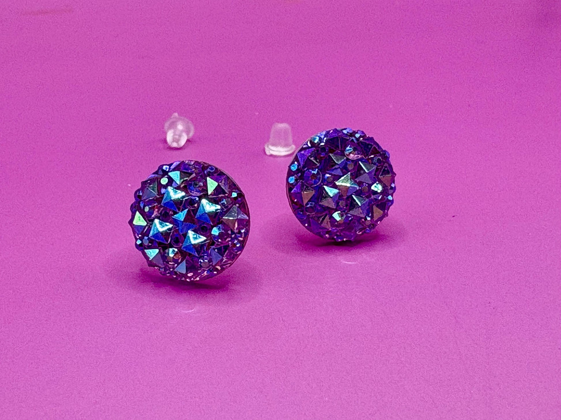 Dazzling purple stud earrings with sparkling gemstones, perfect for adding a touch of elegance to any outfit and enhancing your jewelry collection.