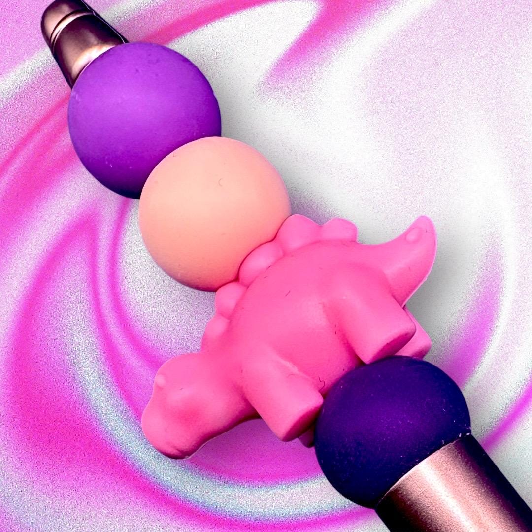 pink dinosaur pen Elevate your writing experience with our delightful Dinosaur-Themed Black Ballpoint Pens! Each pen features a whimsical design, complete with colorful beads including camouflage and adorable pink or grey dinosaur toppers, making them the perfect addition to your stationery collection or a standout gift for anyone who loves fun and functionality.