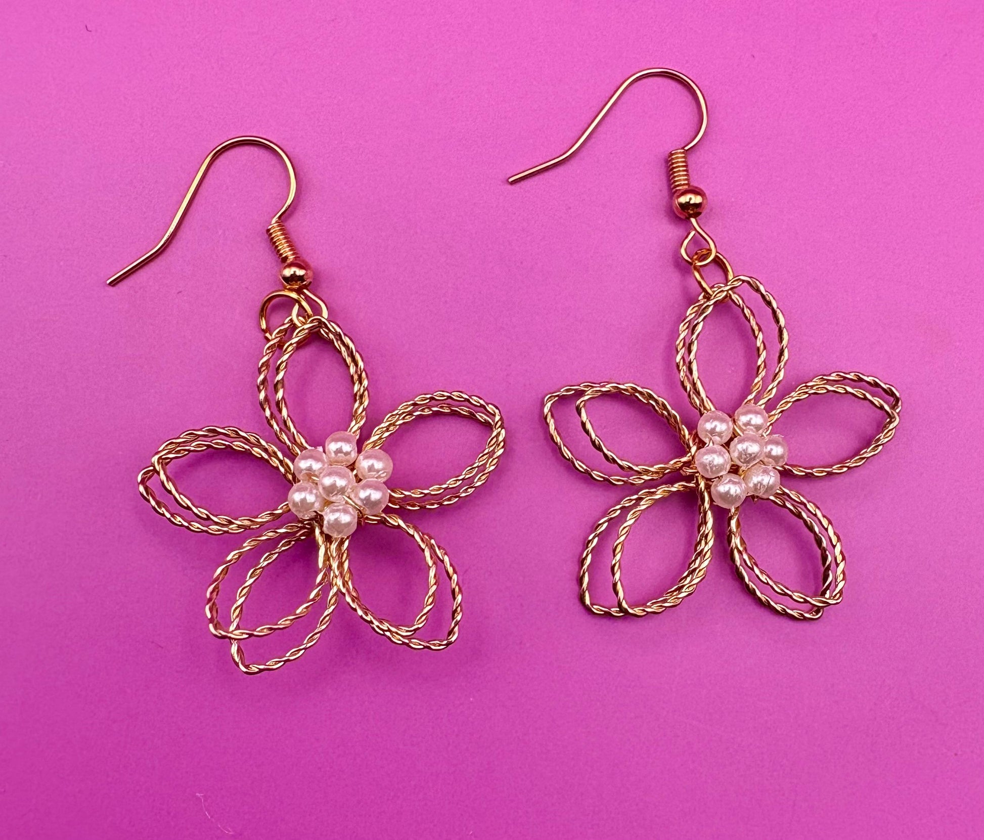 Gold look flower pearly centre dangly earrings