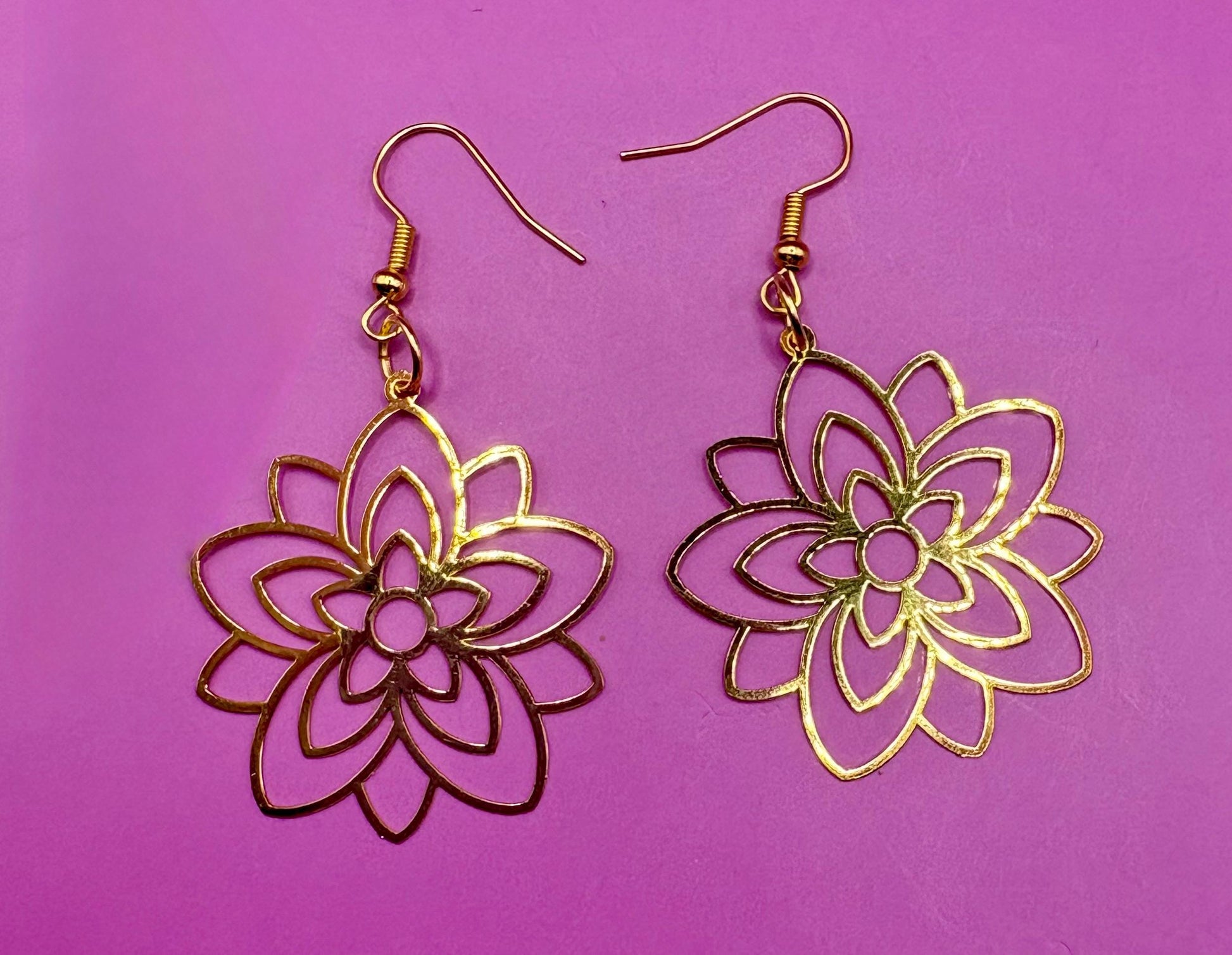 Elegant gold look flower dangly earrings featuring a stunning pearly center, perfect for adding a touch of sophistication to any outfit or as a beautiful gift for jewelry lovers.