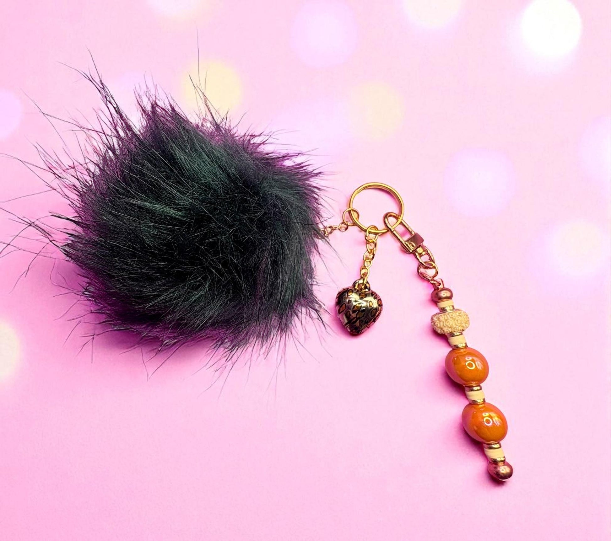 bag charm keychain orange beads gold leopard print heart pendant and black fluffy ball
